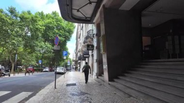 Lizbon 'da güneşli bir gün. İnsanlar renkli Portekiz sokaklarında yürüyor.