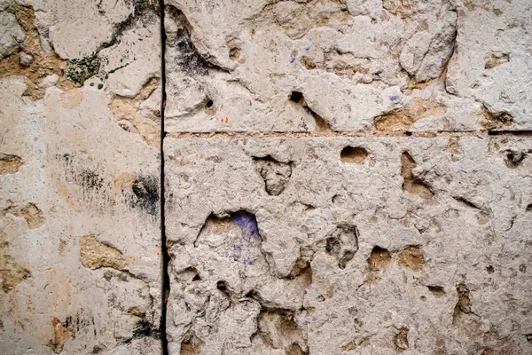 Çatlakları ve çizikleri olan eski taş bir duvar. Tasarım için soyut arkaplan ve doku.