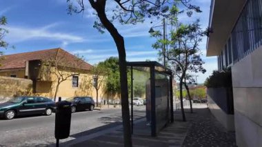 Belem Lizbon 'da mavi gökyüzü ve güneş tarihi döşeli sokaklarda yürüyen turistlerle