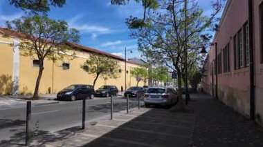 Belem Lizbon 'da gezen turistler güneşli eski sokaklar ve geleneksel Portekiz evleriyle