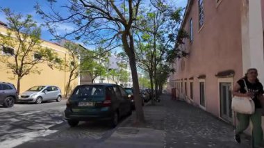 Belem Lizbon 'da güzel fayanslı binalar, güneş ışığı ve keşfeden turistlerle yürüyorum.