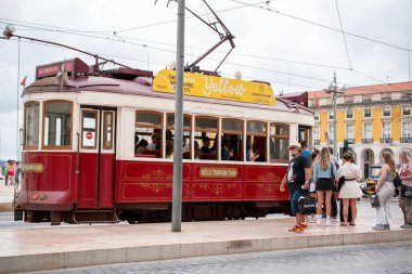 Lizbon 'un ikonik Sarı Tramvayı güneşli bir günde turistlerle