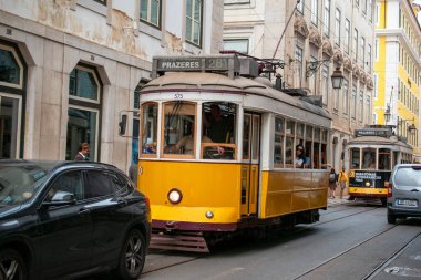 Lizbon 'un ikonik sarı tramvayı kaldırım taşından geçen