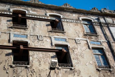 Yapısal destek kirişleriyle tarihi bir binanın harap olmuş cephesi