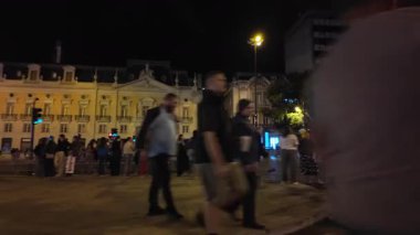 Yürüyen insanlar ve yaz ışıklarıyla dolu Lizbon 'da canlı bir gece sahnesi