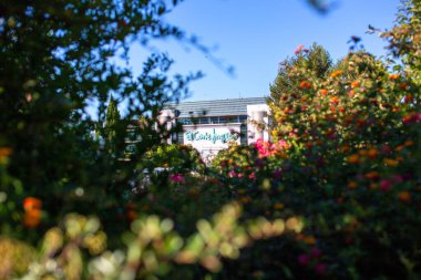 Güneşli bir günde yeşillikle çerçevelenmiş El Corte Ingles binası