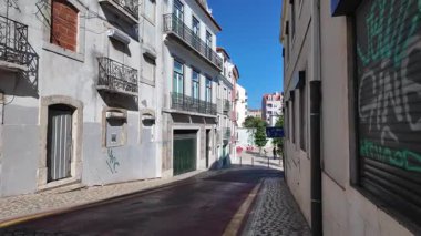 POV Lizbon Portekiz yürüyüş videosu, geleneksel mimari ve Avrupa turizmi ile eski şehir sokaklarında aydınlık yaz günü