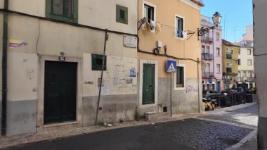 Turist POV Lizbon 'un eski şehir merkezinde yürüyor Portekiz' in tarihi evleri, seyahatleri ve turizm konseptiyle güneşli bir atmosferi var