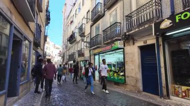 Güneşli POV Lizbon Portekiz yürüyüşü, fayanslarla döşeli eski şehir merkezi, tarihi seyahat mimarisi ve Avrupa turizmi