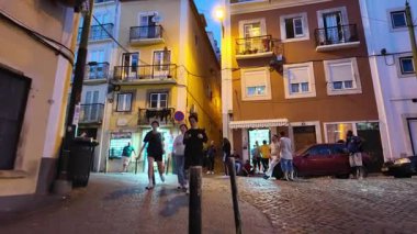 Lizbon 'un tarihi merkezinde POV yürüyüşü Yazın alacakaranlıkta parlayan kaldırım taşı sokaklarıyla