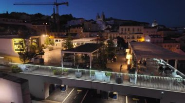 Lizbon 'da yürüyen akşam caddeleri tarihi binalar ve sıcak ışıklarla dolu.