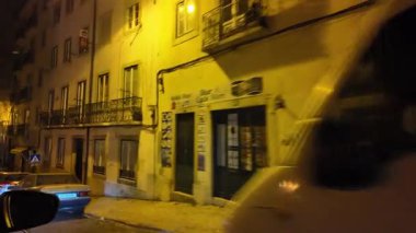 Taksiden POV gece görüşü Lizbon Portekiz sokakları aydınlatılmış şehir ışıkları gece hayatı kentsel seyahat stoku atmosferi