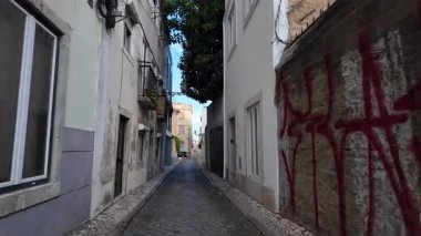 Lisbon walking tour POV, historic architecture, summer sunshine, Europe travel concept