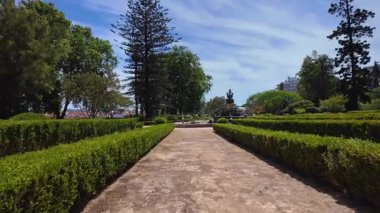 Walking through Lisbon city park bright summer sunlight green trees Europe vacation travel background