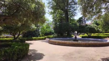 Stroll Lisbon park summer sunlight green trees path Europe travel scene with architecture city