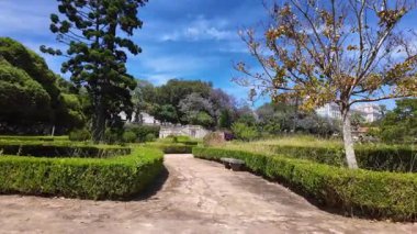 POV walking through Lisbon public park summer greenery sunshine Europe holiday city architecture