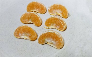 Soyulmuş portakal dilimleri beyaz arkaplanla izole edilmiş