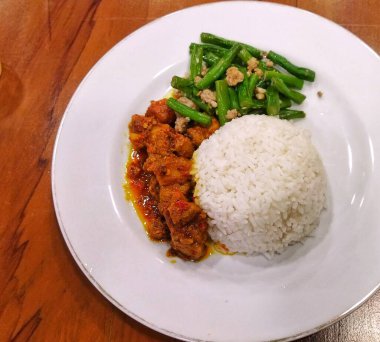 Domuz etli pilav ve kızarmış yeşil fasulye tabağı.