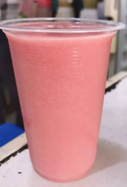 Guava juice in a plastic cup at a juice stall