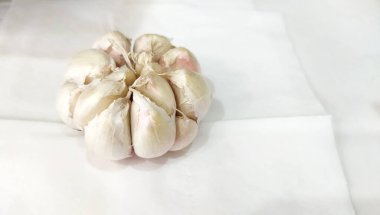 Beyaz sarımsak ampulü beyaz kağıtta izole edilmiş.