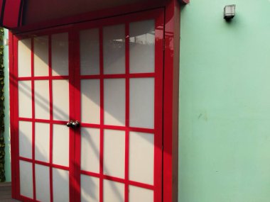 Red and white door next to green wall  clipart