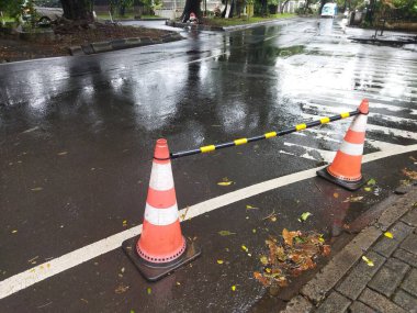 Arabaların durmaması ya da yağmurlu bir günde oraya park etmemesi için yol kenarındaki çekilebilir koni barı