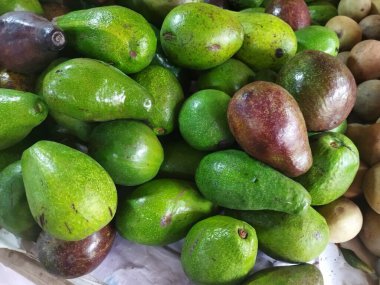 Bir yığın taze avokado, biraz yeşil ve biraz da olgun.