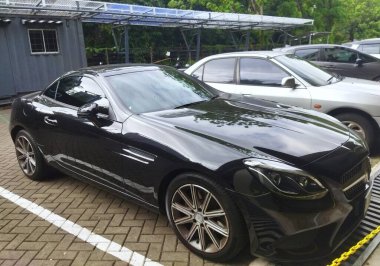 Jakarta - 1 Nisan 2025: Açık bir park yerine park edilmiş siyah bir Mercedes-Benz SLK manzarası