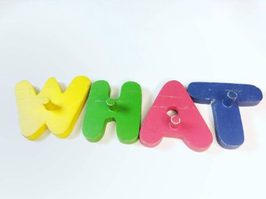 Yakın plan çekimde dört renkli tahta alfabe yapboz parçası beyaz arkaplanda 