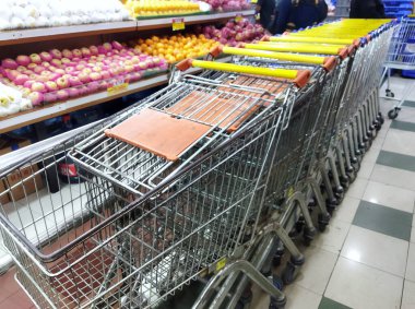 Jakarta - 28 Eylül 2025: Yuvalanmış alışveriş arabaları Hari-Hari süpermarketinde taze meyve sergisinin yanında duruyor