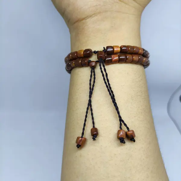 2 kaokah prayer beads bracelets in the shape of a brown box worn on the right hand as additional fashion accessories