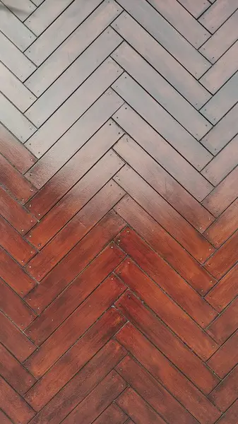 Old oak herringbone parquet with zigzag motif. Wooden floors, point de Hongrie style. Typical Parisian floor. Close-up herringbone style pattern in vertical shot