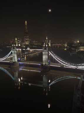 Gece Londra 'daki Tower Köprüsü. Arka planda St. Paul Katedrali ve Çömlek Kulesi var. Ay Thames Nehri 'ne yansıdı. Yüksek açılı. Görünüm oranı: Dikey.