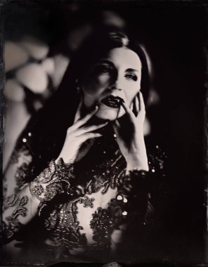 Korkunç bir gotik pencerenin önündeki korkunç dişi vampir (4 'ün 4' ü). Karanlık atmosferik aydınlatma, 19. yüzyıl kimyasal işlemleri ile çekilmiş siyah beyaz fotoğraf.