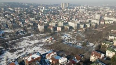 Parlak bir kar yağışı altında büyük bir şehrin huzur dolu dönüşümünü yaşayın. İnsansız hava aracımız, kışın güzelliğinin resmedildiği şehir manzarasını yakalıyor..