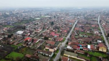 Sırbistan 'da küçük bir kasabanın havadan görünüşü, çatılar ve sisli trafiğin yavaşlaması