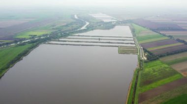 Sisli havada kırsalda balık havuzlarına doğru uçuyor.