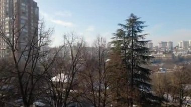 Güneşli kış gününde karla kaplı büyük bir şehrin insansız hava aracı görüntüleri.