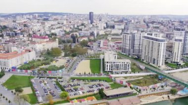 Nehrin üzerinde köprüsü olan bir şehir. Sonbahar sabahı otoparklar ve bina kompleksleri.