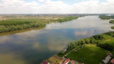 Sırbistan 'da Tuna nehrinin nehir kıyısındaki küçük bir köydeki kır evlerinin panoramik hava manzarası