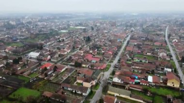Sırbistan 'da küçük bir kasabanın havadan görünüşü, çatılar ve sisli trafiğin yavaşlaması