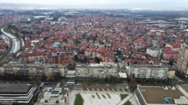 İHA yukarı doğru uçar ve aşağıdaki kırmızı çatıların büyüleyici görüntüsünü yakalar.