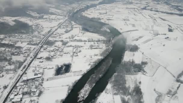 Εναέρια Πλάνα Ενός Ποταμού Που Διασχίζει Μια Πόλη Καλυμμένη Χιόνι — Αρχείο Βίντεο