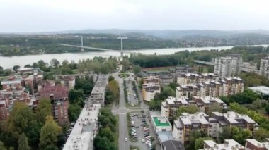 Tuna nehri üzerinde bir köprü ve binaların, spor salonlarının ve parkların havadan göründüğü bir şehir manzarası.