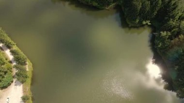 Yükselen insansız hava aracı görüntüleri Sırbistan 'daki Radalj Gölü ve etrafındaki ormanı yakalıyor