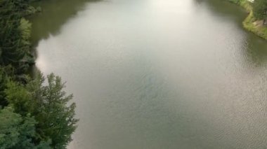 Göl 'ün yüzeyi İHA bakış açısıyla kıyıda ağaçlarla çevrili.