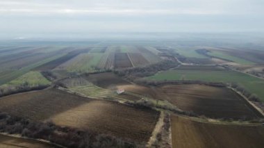 Uçsuz bucaksız gökyüzünün altında uzanan geniş tarım alanlarının panoramik görüntüsü