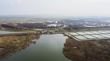 Balık havuzları ve bulutlu havalarda bataklıklarla çevrili eski evlerin havadan görünüşü