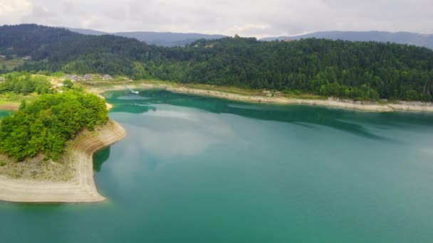 항공기는 언덕과 숲으로 둘러싸인 명확한 호수의 — 비디오
