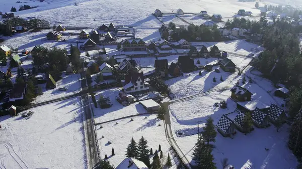 Sırbistan 'ın Zlatibor kentinde karla kaplı küçük evler ve bungalovların hava manzarası